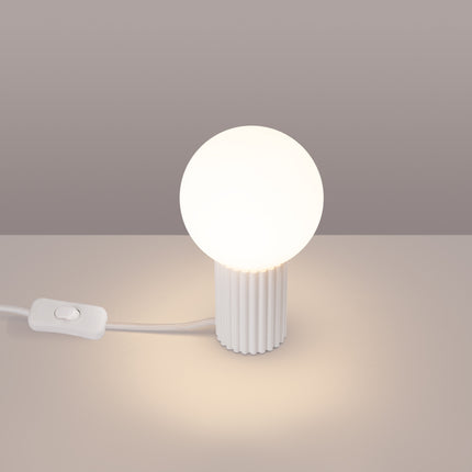Lampe à poser Halo blanche allumée, lumière chaude diffusée par le globe en verre opalin