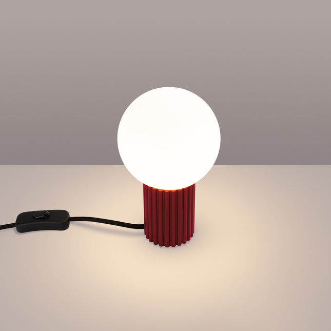 Lampe à poser Halo bordeaux allumée, lumière chaude diffusée par le globe en verre opalin