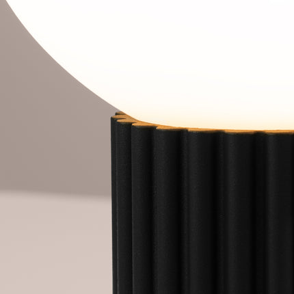 Détail des cannelures verticales du socle en aluminium noir sous le globe en verre opalin