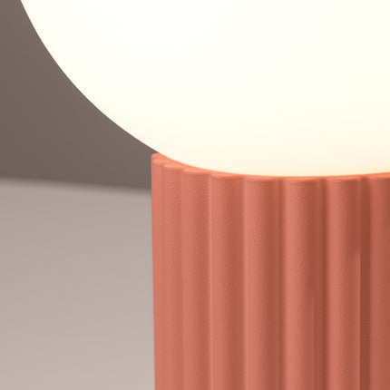 Détail des cannelures verticales du socle en aluminium pêche sous le globe en verre opalin