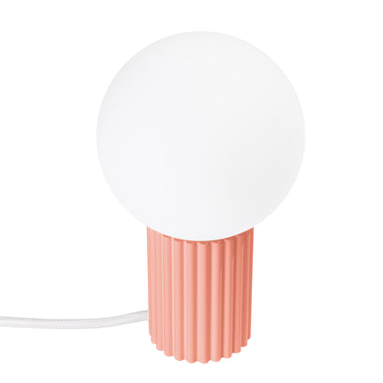 Lampe à poser Halo pêche, globe en verre opalin et socle cannelé en aluminium, vue de face sur fond blanc