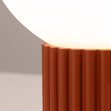 Détail des cannelures verticales du socle en aluminium rouge ocre sous le globe en verre opalin