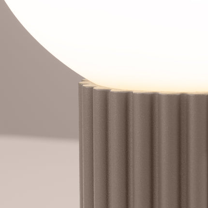 Détail des cannelures verticales du socle en aluminium taupe sous le globe en verre opalin