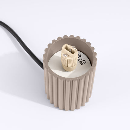 Détail du culot G9 en céramique à l'intérieur du socle en aluminium taupe