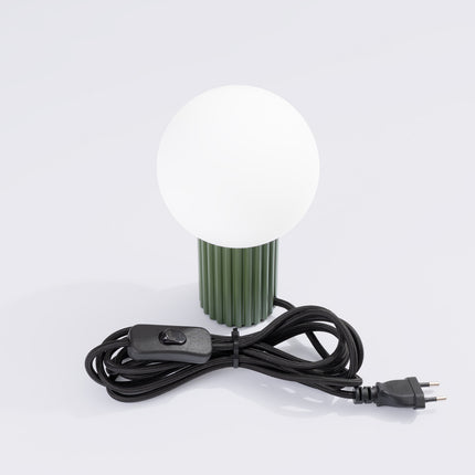 Vue rapprochée du socle cannelé en aluminium vert olive et du globe en verre opalin