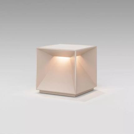 Lampe Nutalis vue en angle, structure pyramidale intérieure en aluminium beige sable, fond gris studio.