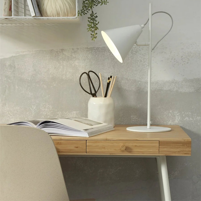 Lampe à poser Lisbon blanche allumée, lumière douce diffusée sur un bureau
