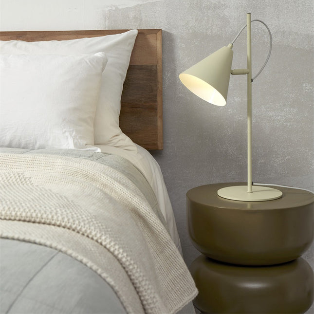 Lampe à poser Lisbon vert doux allumée sur une table de chevet en bois