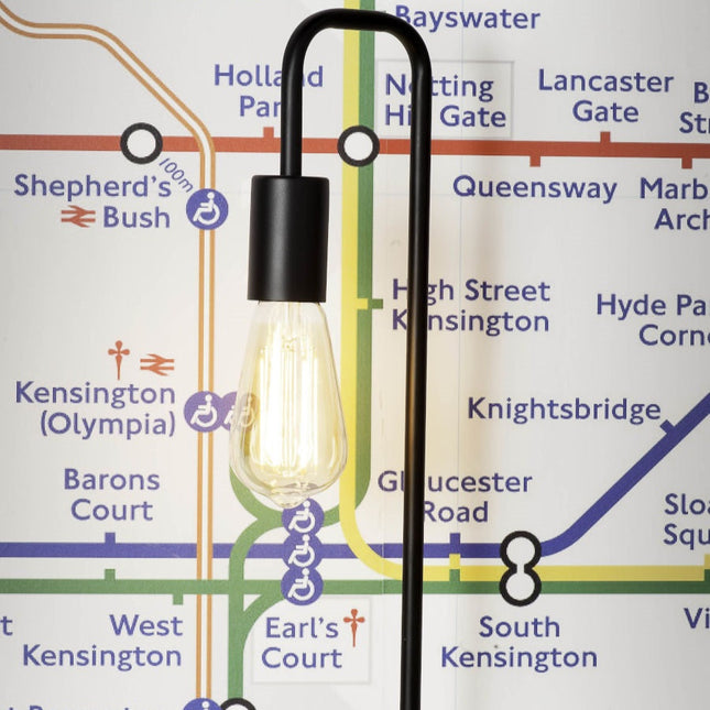 Lampe à poser London en fer noir avec cage cylindrique et socle en béton, présentée à côté de la version blanche