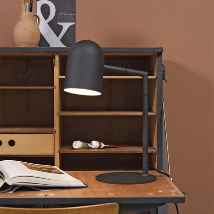 Lampe à poser Marseille noire posée sur une table de chevet, ambiance chambre