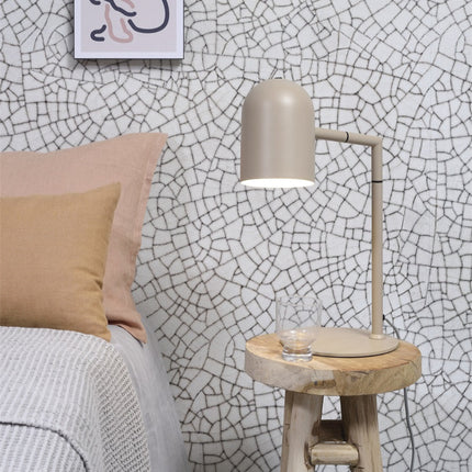 Lampe à poser Marseille sable en fer installée sur une table de chevet