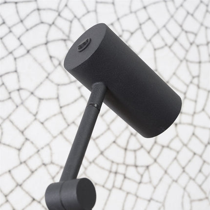 Détail de la tête orientable et de l'interrupteur intégré en fer noir mat