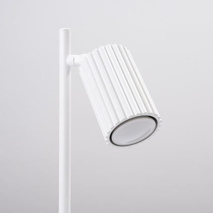 Détail de la lampe Oslo blanc allumée, lumière chaude diffusée par la tête orientable
