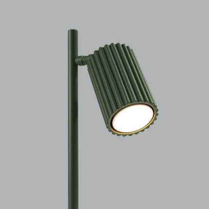 Détail de la lampe Oslo vert allumée, lumière chaude diffusée par la tête orientable