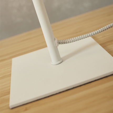 Détail de la base carrée en fer blanc et du raccord du câble textile de la lampe Perth