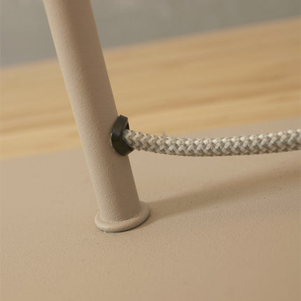 Détail de la fixation du câble textile tressé sur le pied en fer sable de la lampe