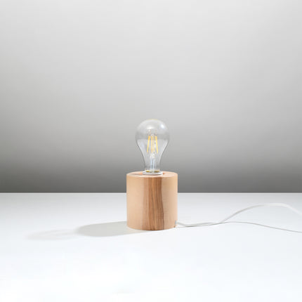 Lampe à poser socle cylindre en bois naturel avec ampoule filament E27 et câble blanc, sur fond gris.