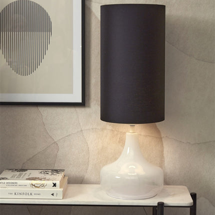 Lampe à poser Reykjavik allumée sur console, verre blanc et abat-jour coton noir