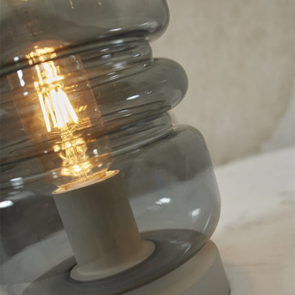 Vue rapprochée des volumes de verre empilés du pied de la lampe Verona
