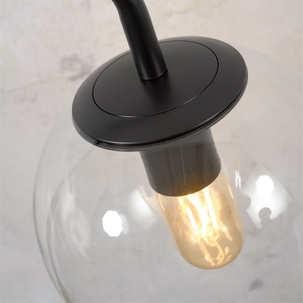Gros plan sur la douille E27 noire et l'ampoule au centre du globe en verre soufflé de la lampe Warsaw