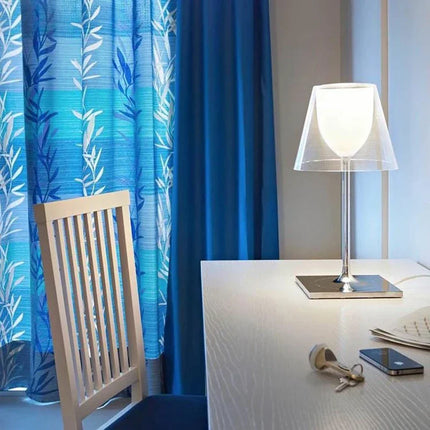 Lampe acrylique design italien posée sur une table de chevet