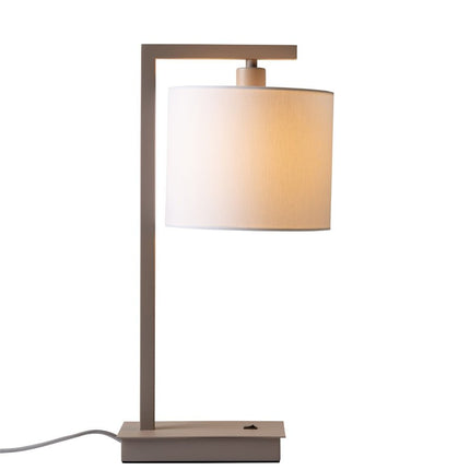 Lampe Boston posée sur une table de chevet, lumière chaleureuse diffusée par l'abat-jour blanc.