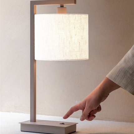 Gros plan sur la fixation en fer sable et l'abat-jour en coton blanc de la lampe Boston.