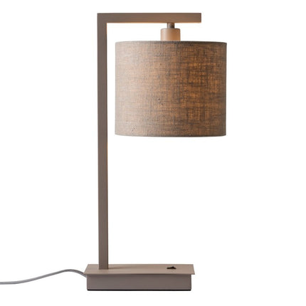 Lampe Boston posée sur une table de chevet, lumière tamisée par l'abat-jour lin foncé.