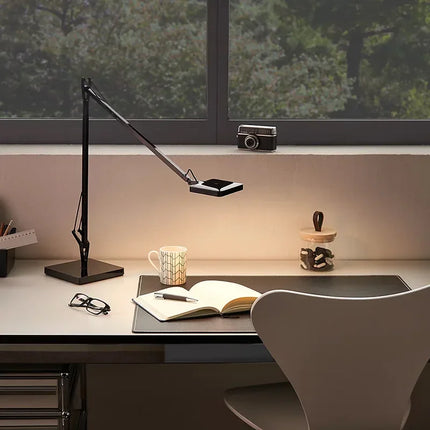 Lampe de bureau LED italienne à bras articulé posée sur un bureau