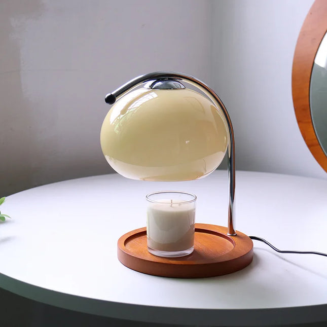 Lampe chauffe-bougie rétro en verre posée sur une table