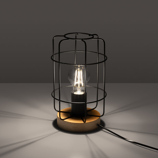 Lampe de table Cage Industrielle allumée, ampoule à filament visible dans la cage en acier