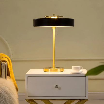 Lampe de table dorée éclairant un coin salon d'une lumière douce