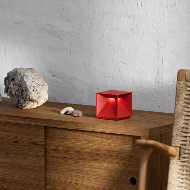 Lampe à poser LED Nutalis rouge en aluminium posée sur un meuble en bois, lumière chaude diffusée