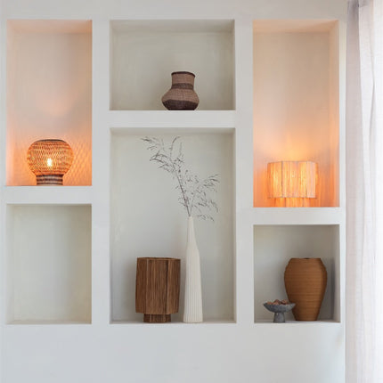 Niches murales éclairées mettant en valeur des lampes en raphia tressé de la gamme Panama