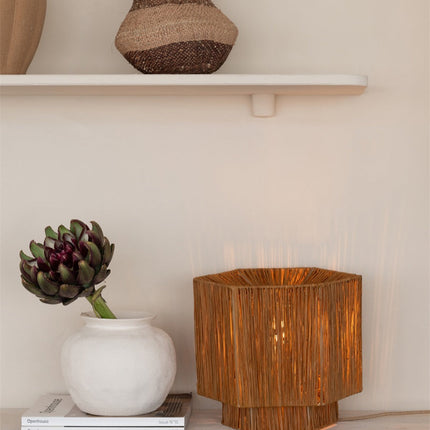Lampe Panama allumée posée sous une étagère, à côté d'un vase et d'un artichaut décoratif
