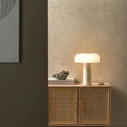 Lampe artisanale en pierre blanche à ampoule LED, design épuré et économe.