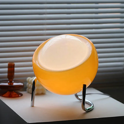 Lampe à poser circulaire orange allumée en lumière chaude