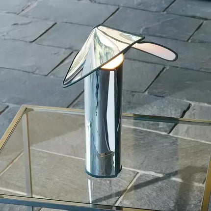 Lampe à poser nordique en acier sur une table de chevet dans une chambre