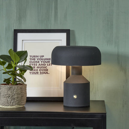 Lampe à poser Porto noire allumée sur une console, ambiance chaleureuse