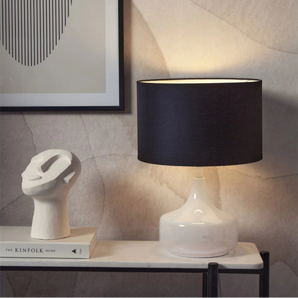 Lampe à poser Reykjavik sur une table de chevet, pied en verre blanc et abat-jour en coton noir