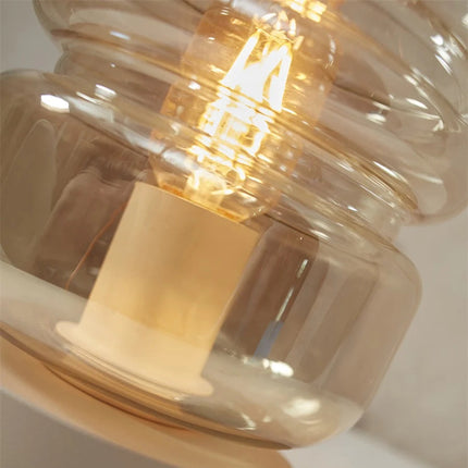 Gros plan sur l'ampoule et le verre dégradé ambre de la lampe Verona allumée