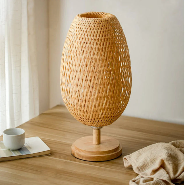 Lampe à poser Wabi-Sabi en rotin allumée dans une chambre