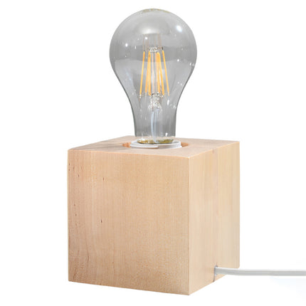 Gros plan de la lampe cube en bois naturel, douille E27 blanche, ampoule filament et cordon blanc.