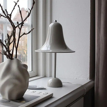 Lampe de table cloche danoise posée sur un bureau minimaliste