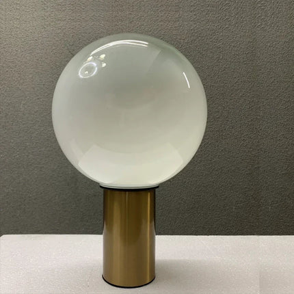 Lampe de table cristal danoise dorée allumée diffusant une lumière douce