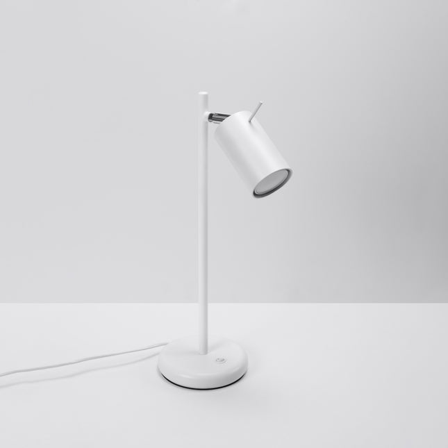Vue de face de la lampe de table blanche, tige fine en acier et tête de spot orientée vers l'avant
