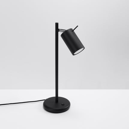 Lampe de table directionnelle noire, tige fine en acier et tête de spot orientée vers l'avant
