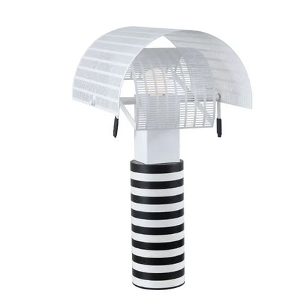 Lampe de table à rayures et grilles éclairant un coin bureau
