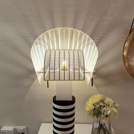 Lampe de table à rayures et grilles sur une console de chambre