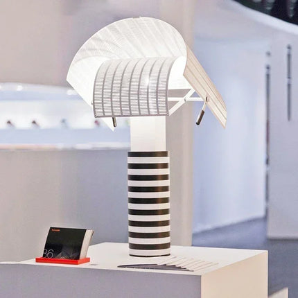 Lampe de table à rayures et grilles posée dans un salon contemporain